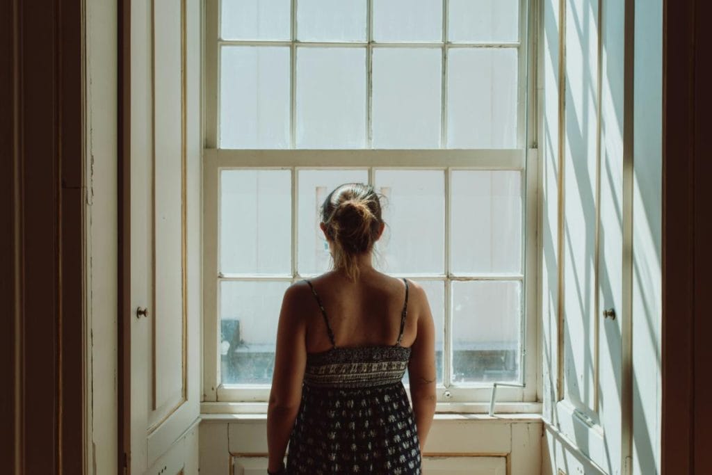 woman in front of window with curtains open