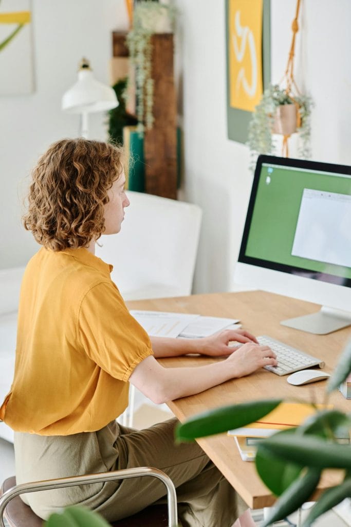 woman working a desktop computer at home