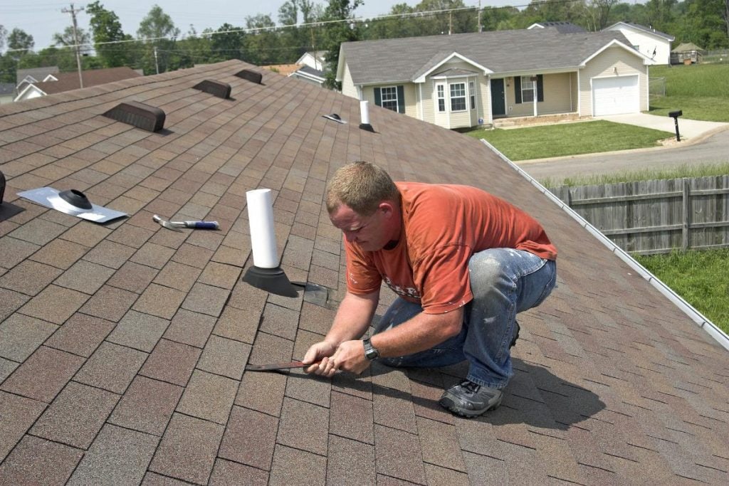 man working on a roof after a storm