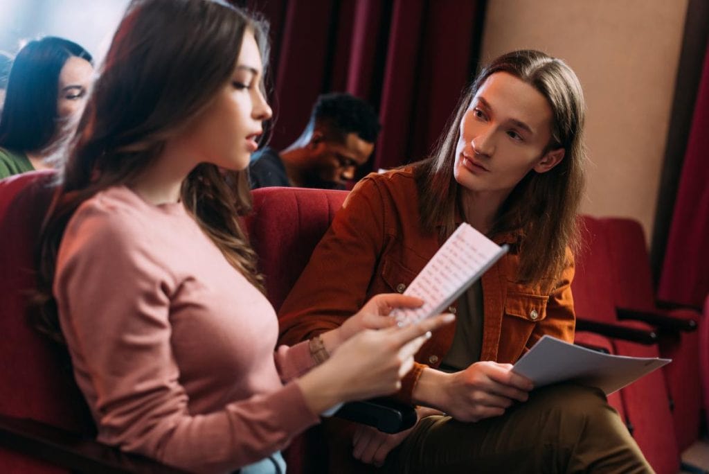 young woman reading a script to a young man