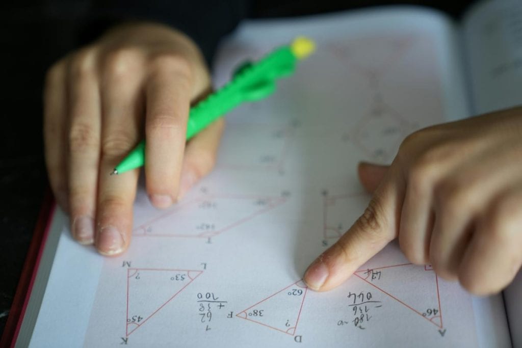 child completing a math worksheet on angles