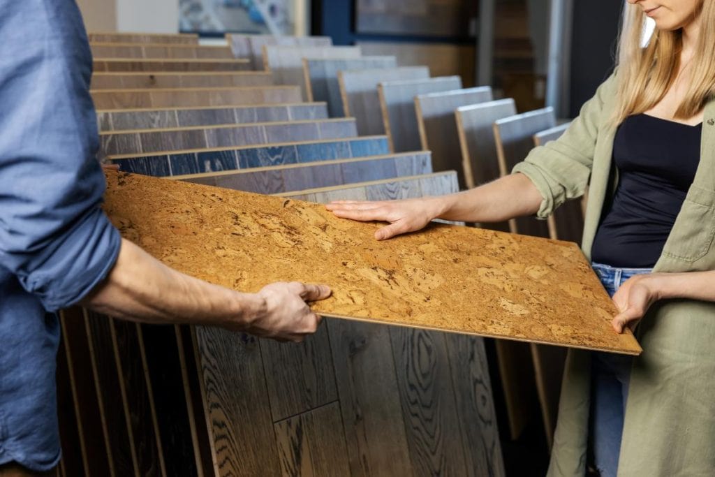 couple holding cork flooring while looking at eco-friendly flooring options in home improvement store