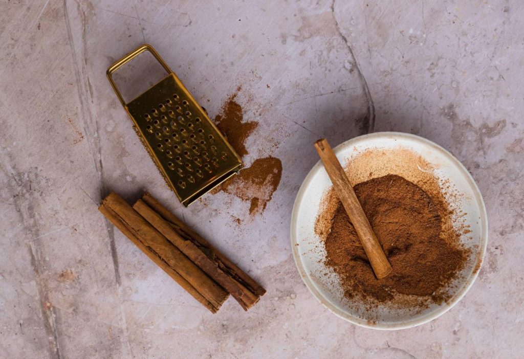 ground cinnamon with a grater and cinnamon sticks