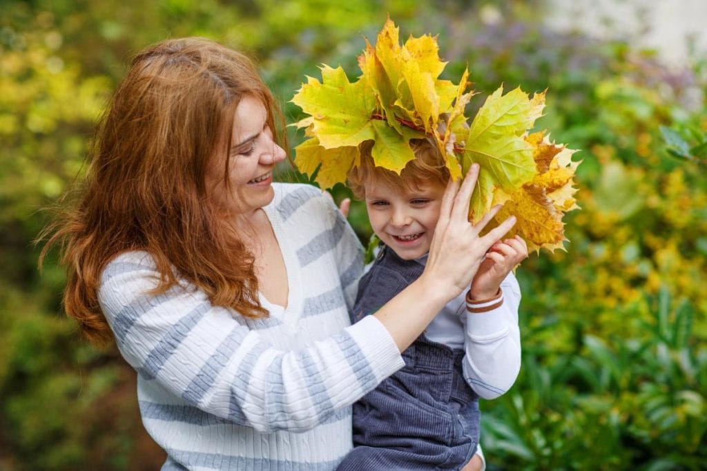 mother holding child wearing a leaf crown