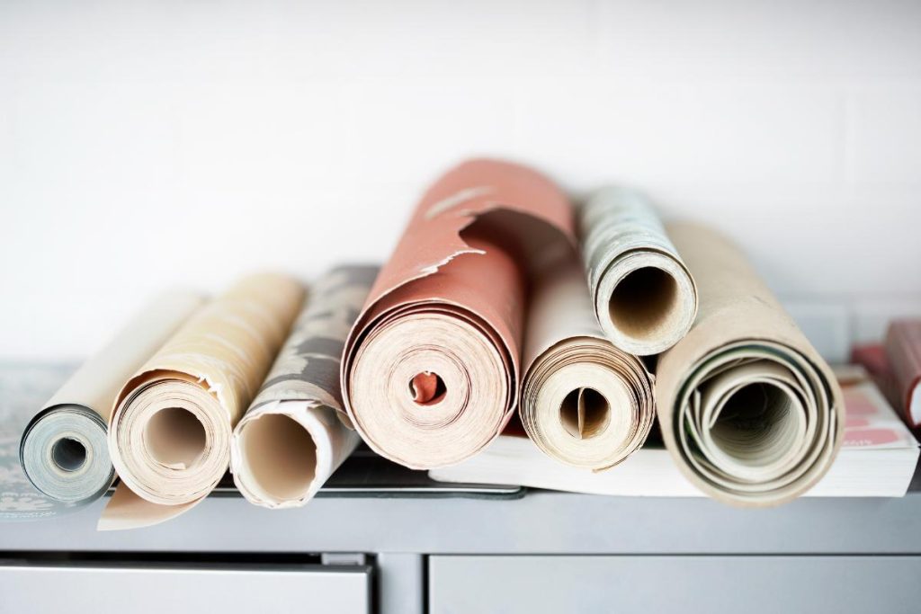 rolls of wallpaper sitting on top of a cabinet