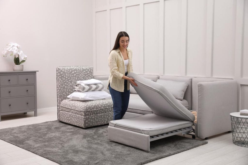 woman preparing a sofa bed for a guest