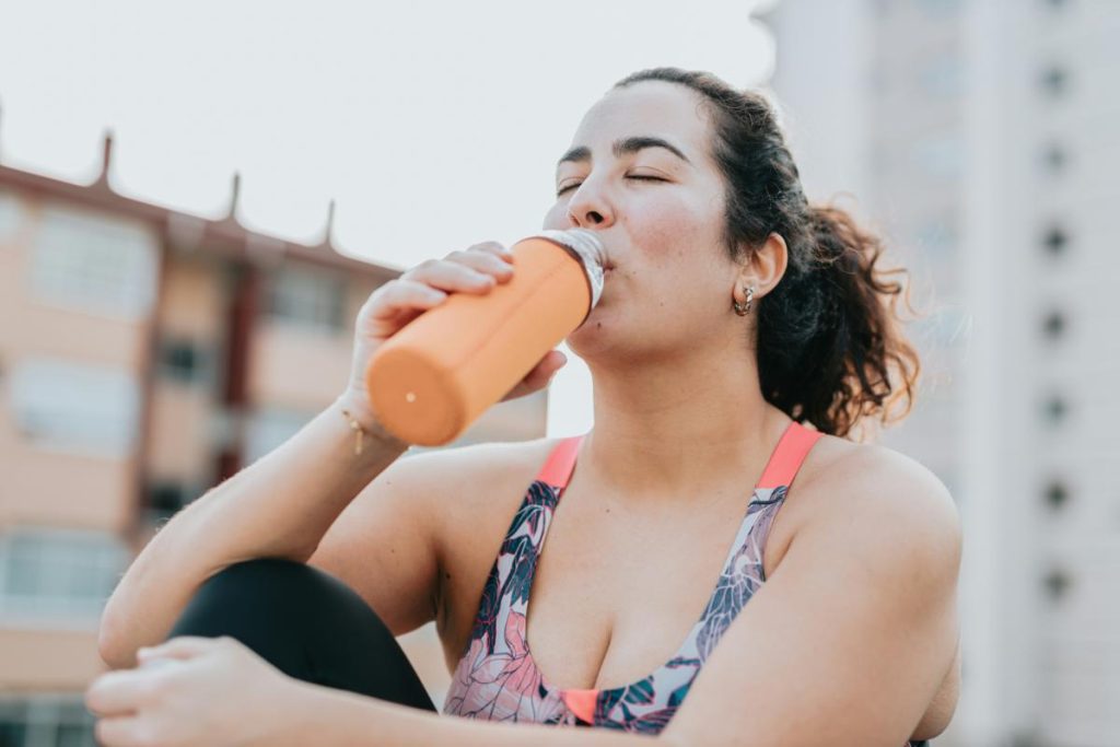 woman drinking from water bottle