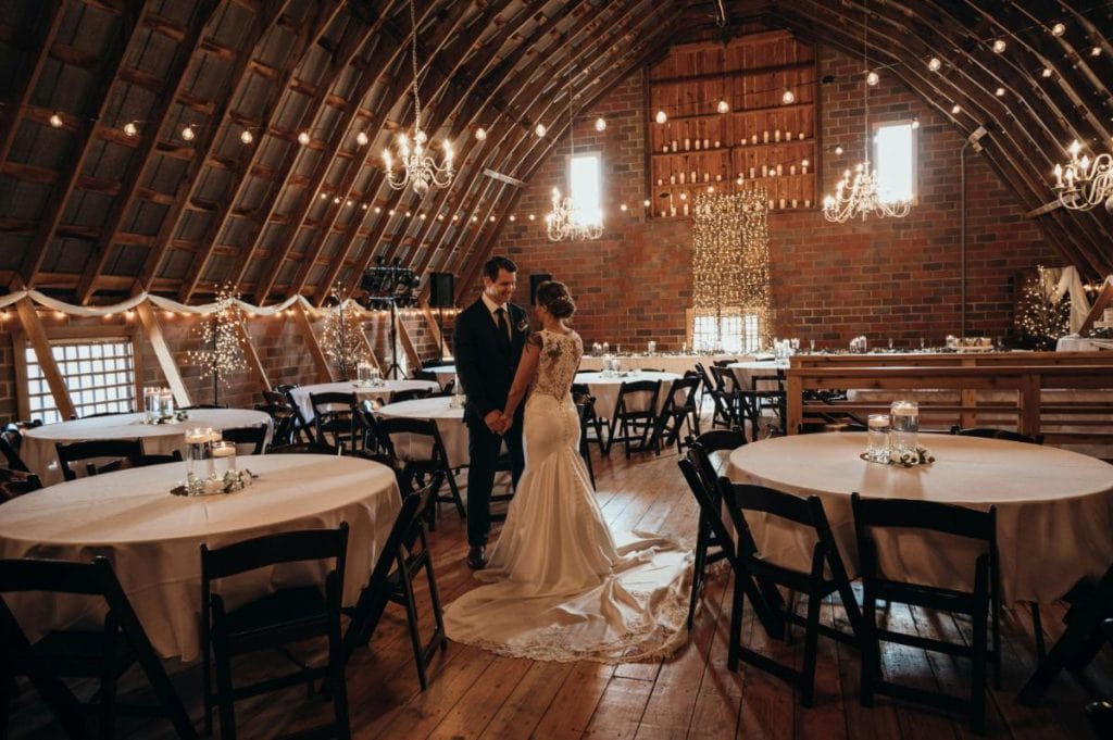 bride and groom looking holding hands in reception hall