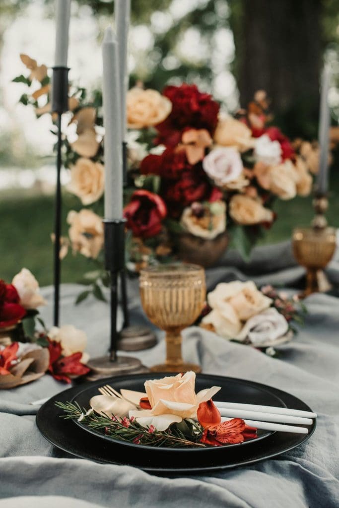 gorgeous flowers, candles, and table settings for an outdoor wedding