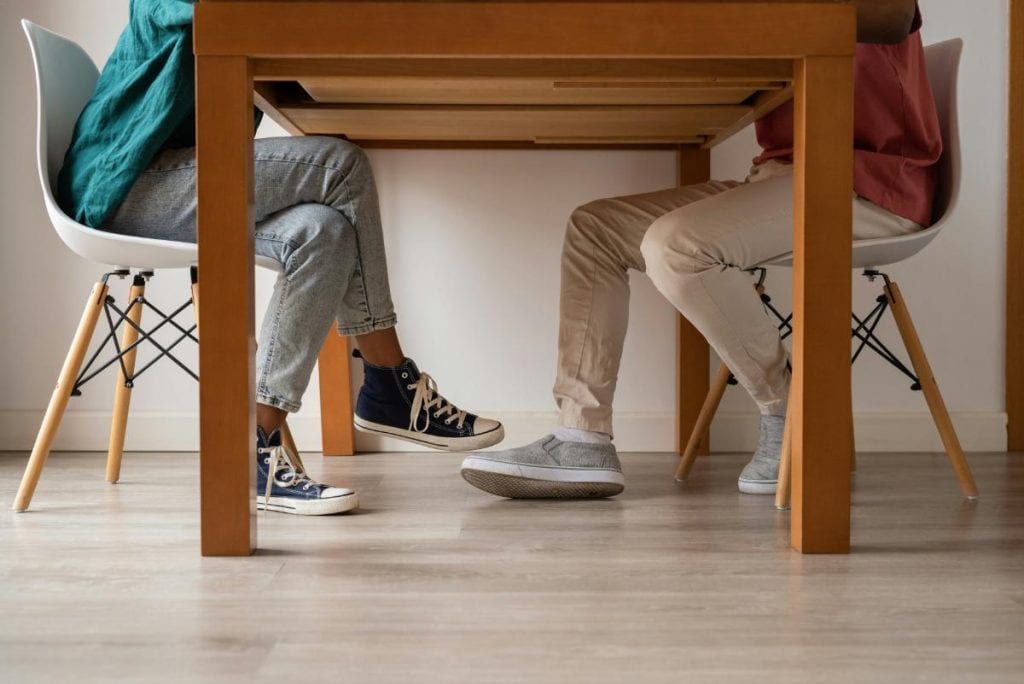 couples legs under a table - couple having a discussion at a table