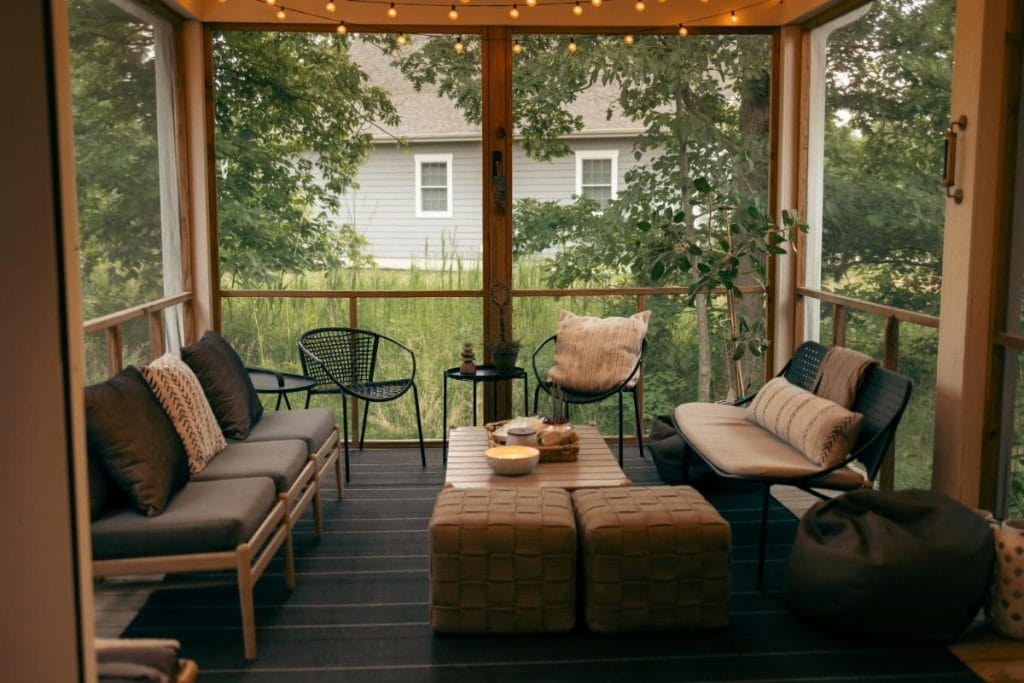 an enclosed porch with comfy furniture for enjoying the outdoors