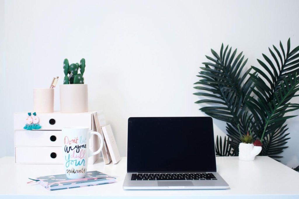 feminine home office setup with fun mug and laptop computer