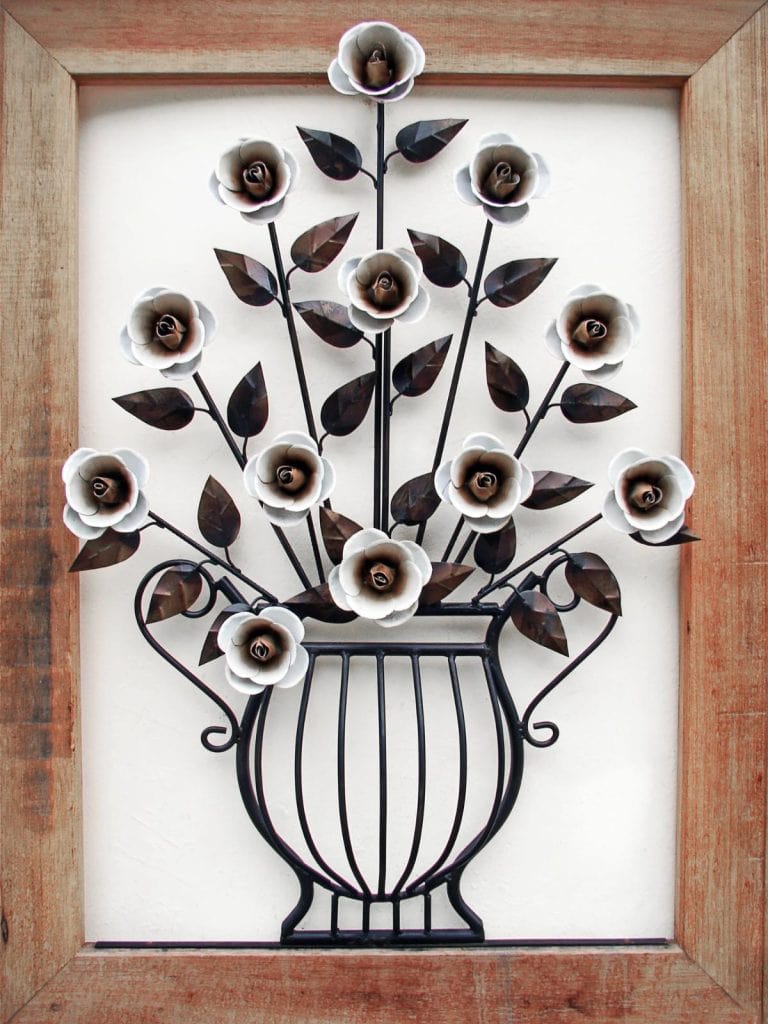 metal flowers and vase inside a wooden frame