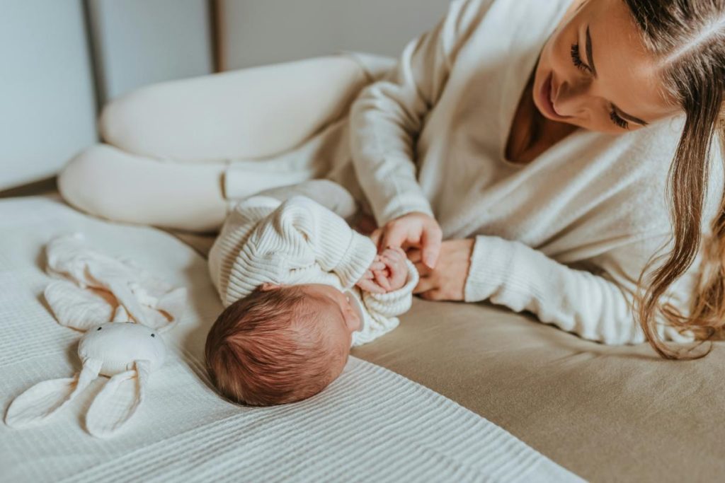 mom on bed with newborn baby