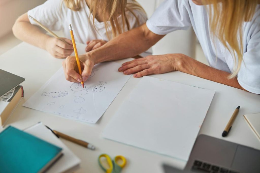 mother and daughter drawing on paper