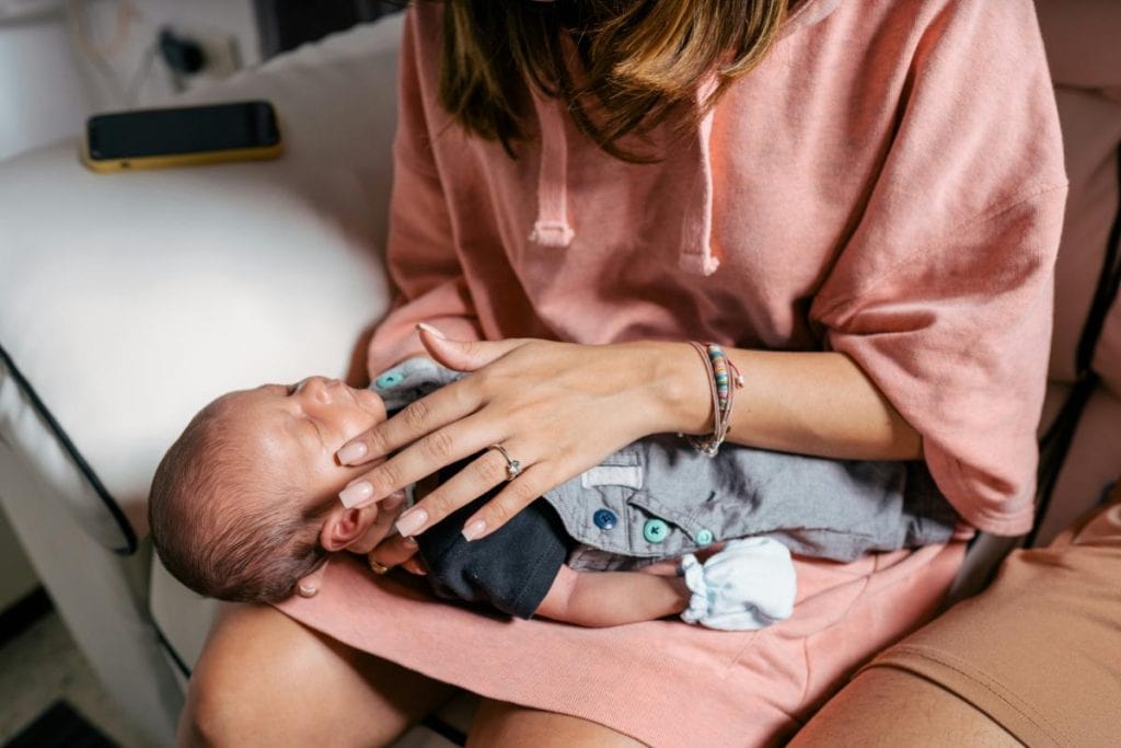 mother in hospital gown holding baby