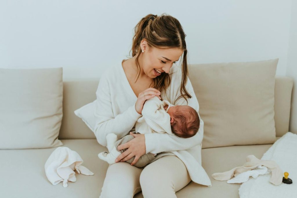 mother sitting on couch holding baby