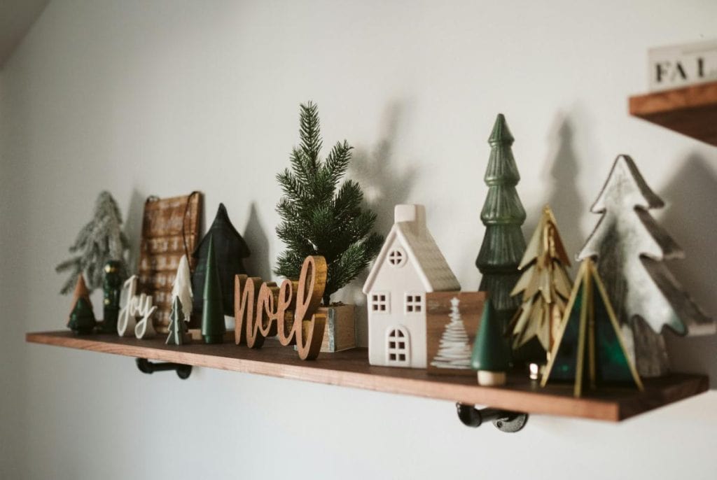 a shelf decorated for Christmas with various miniatures and mini trees