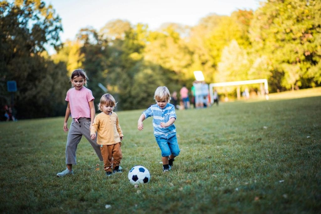 three siblings playing soccer