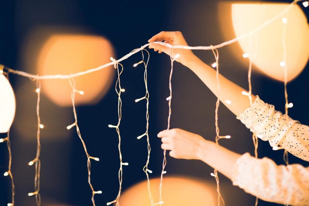 woman holding strand of icicle christmas lights