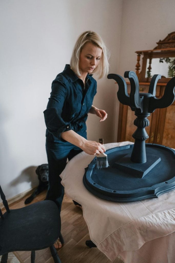 woman painting a small table black