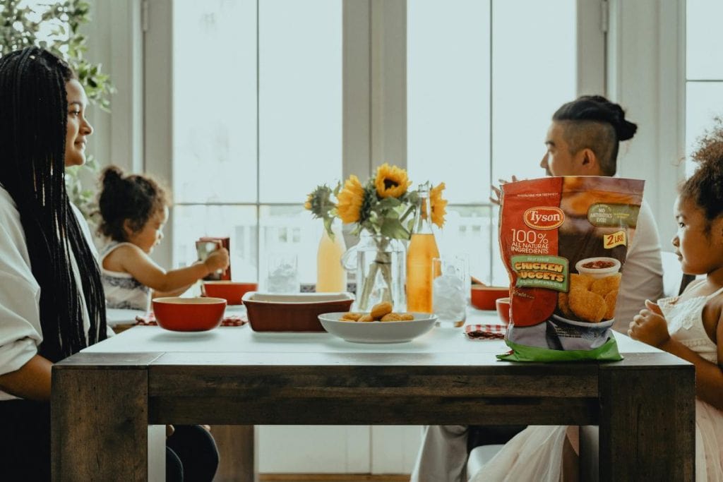 woman sitting at table with family in front of large window