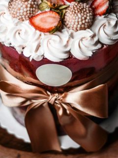 cake decorated with ribbon, icing, and strawberries