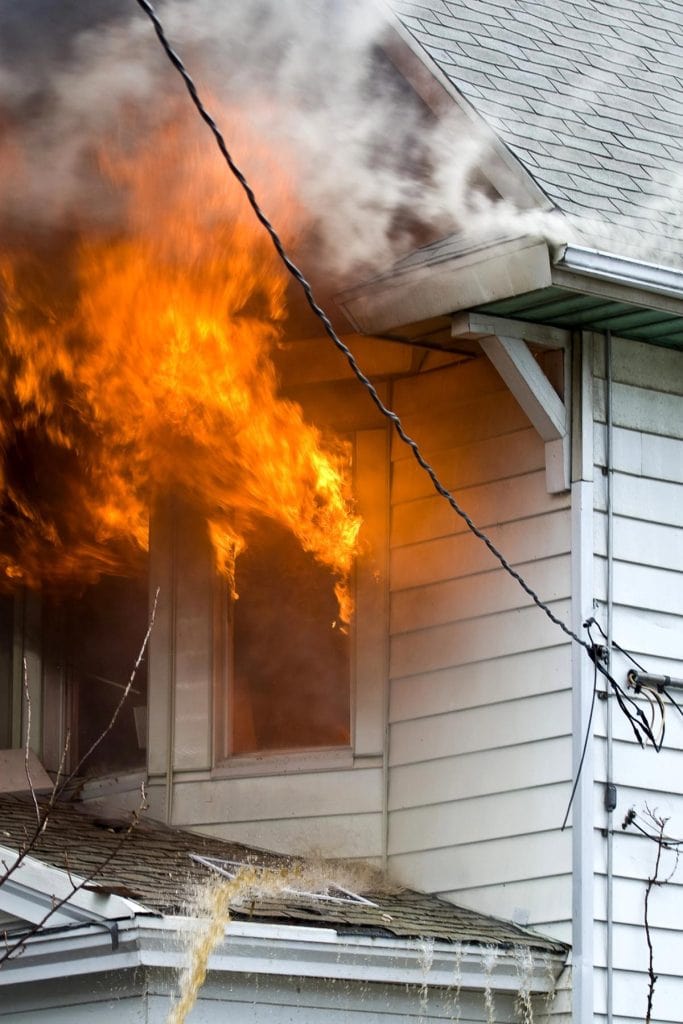 flames coming out of the windows of a white house