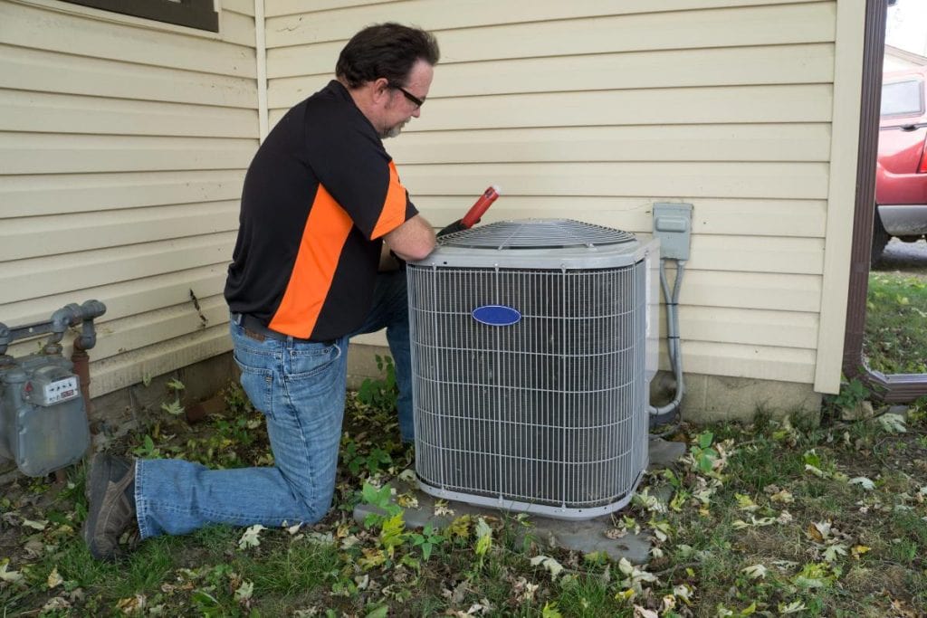 hvac repairman looking at unit