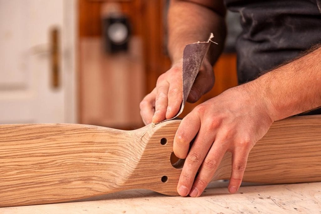 man sanding a piece of furniture