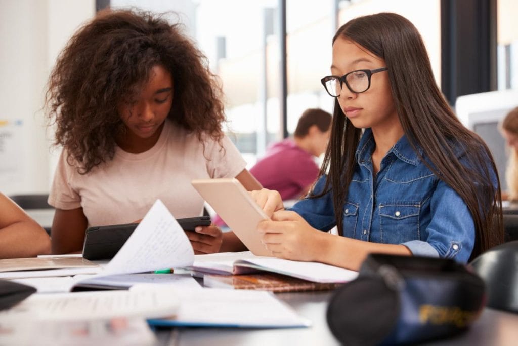 young girls using tablets in classroom