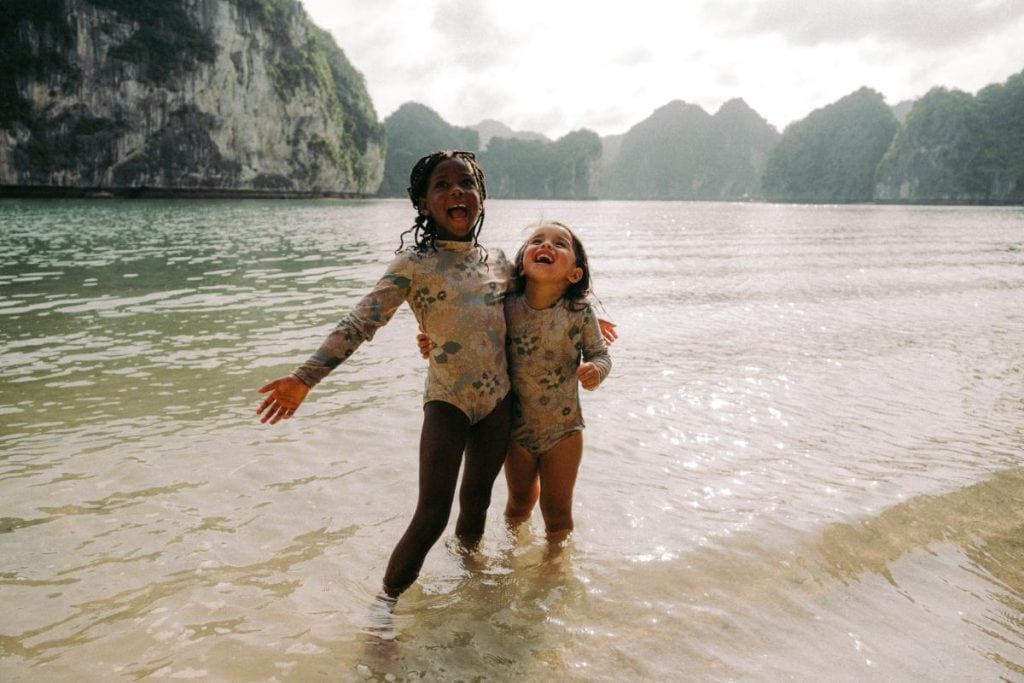 two young girls playing in the water while on vacation