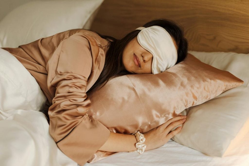 woman asleep in bed with a sleep mask