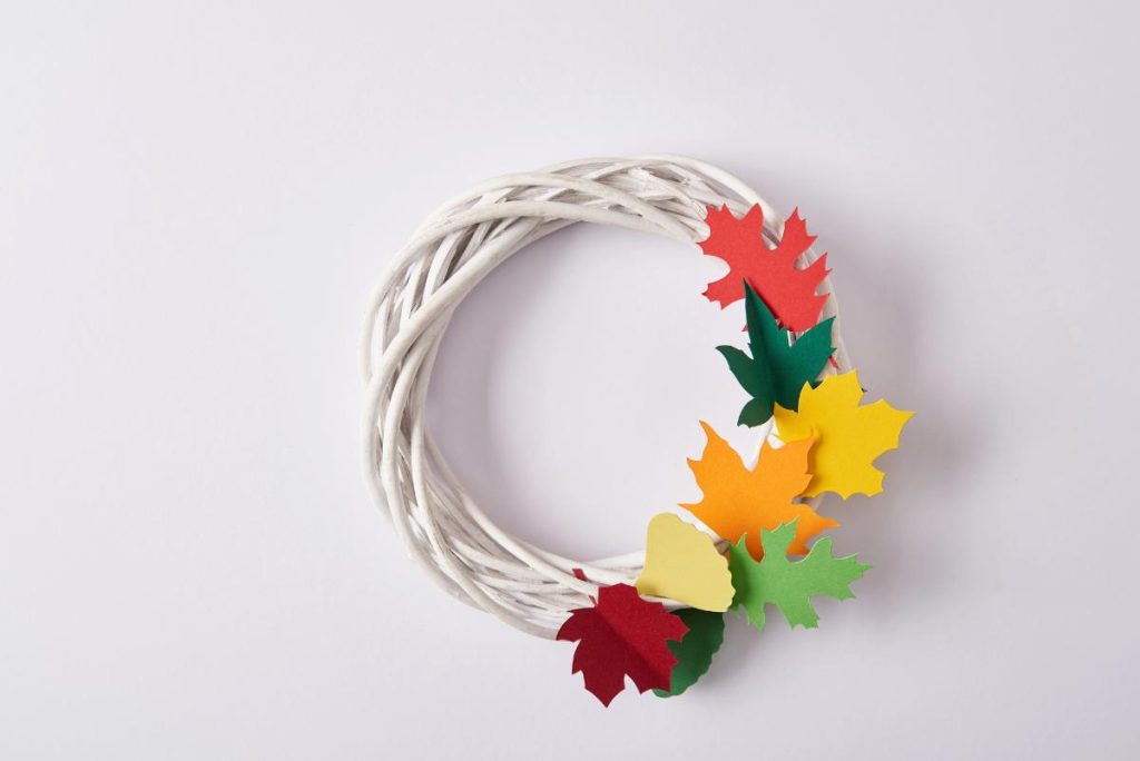 white wreath with paper fall leaves