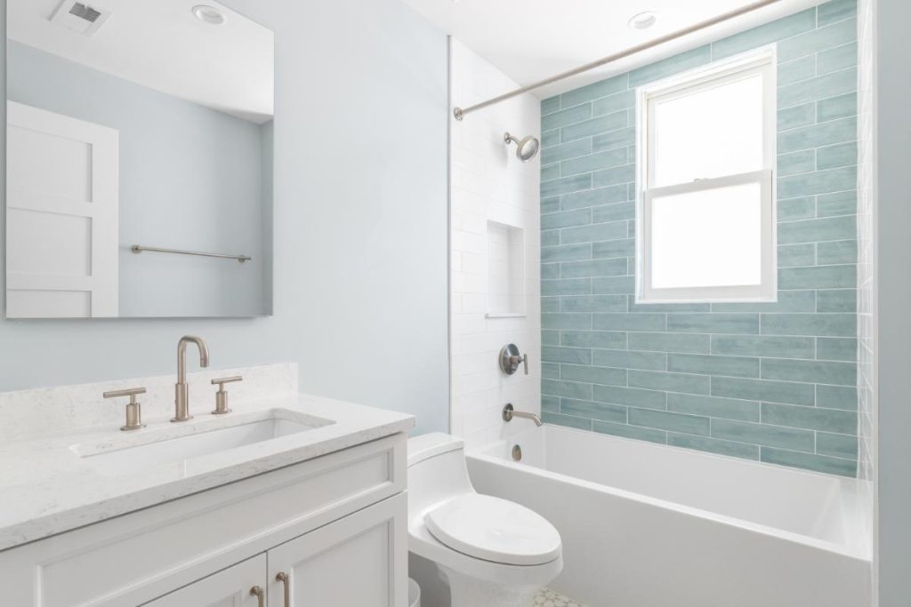 bathroom with white vanity and light blue subway tile