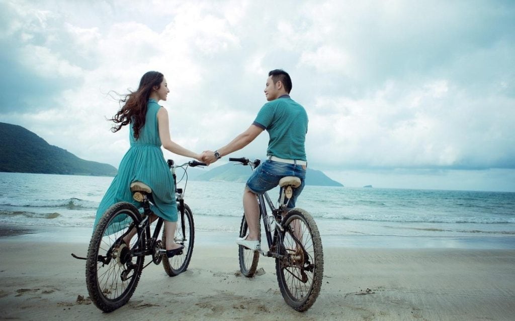 a couple cycling on a beach