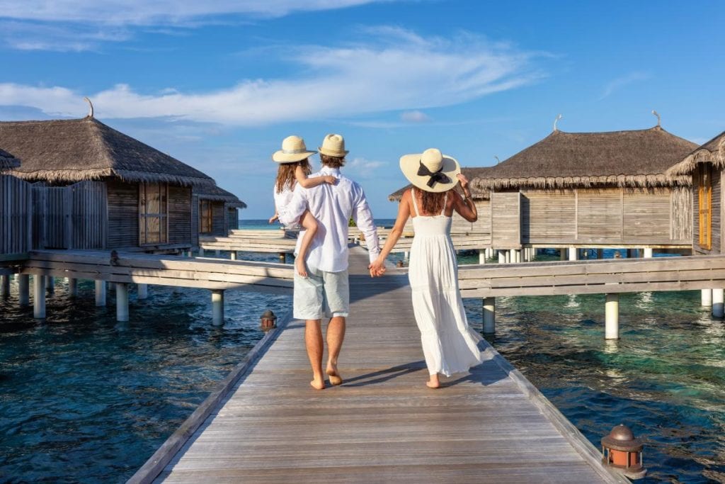 family of three walking on a pier