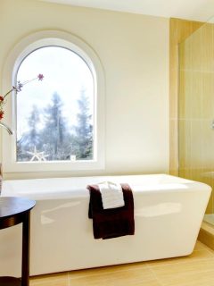 a large luxury bathroom with big white tub