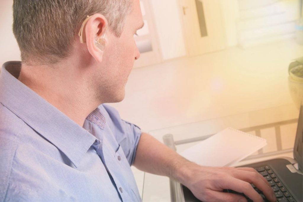 man with hearing loss using laptop