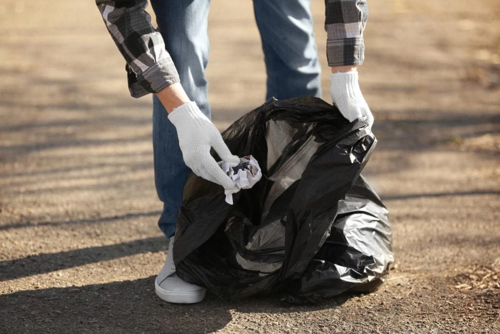 person wearing gloves to pick up litter