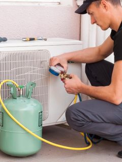 man refilling air conditioner with freon