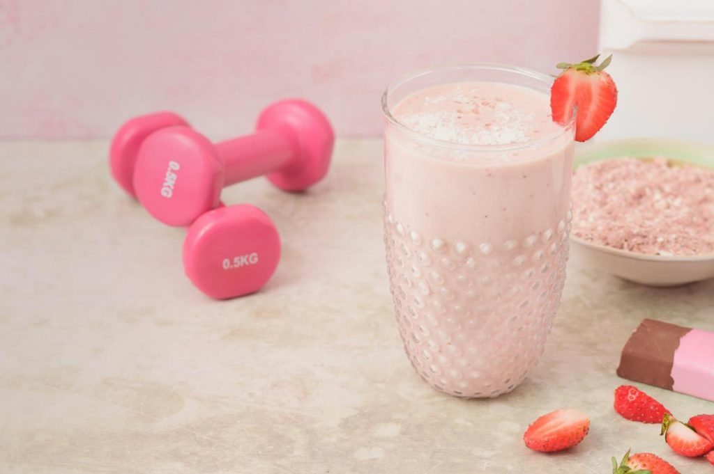 strawberry smoothie with small pink dumbbells