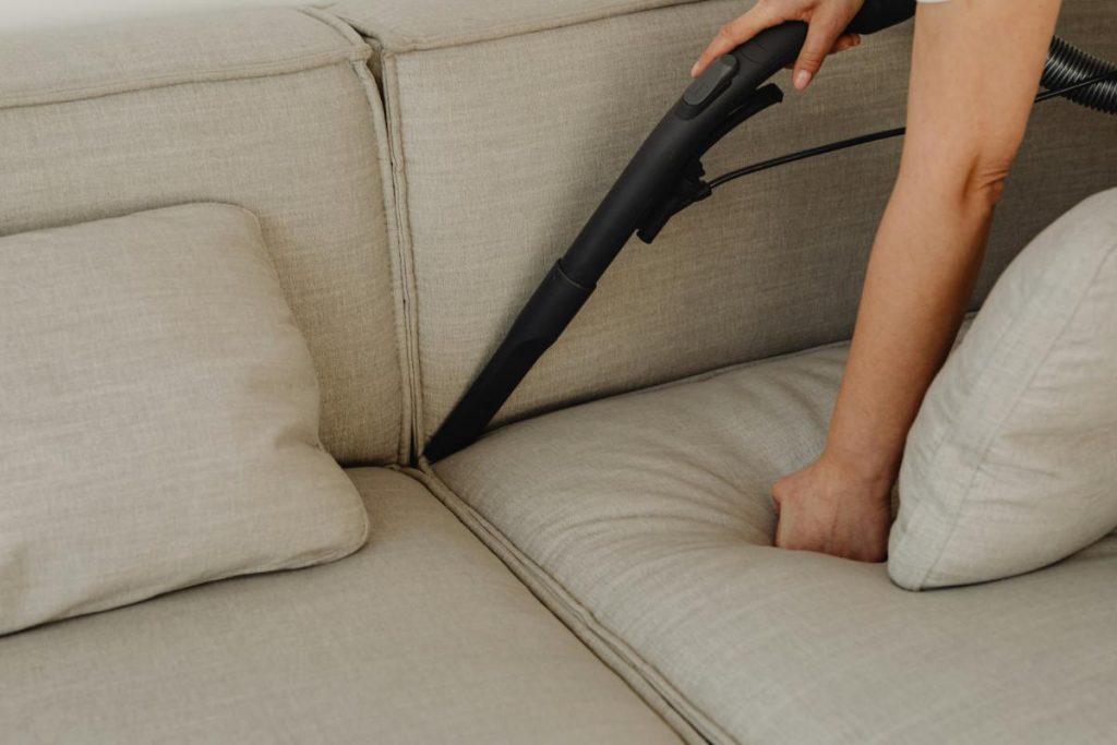 woman vacuuming a couch