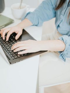 woman using a laptop at a white desk