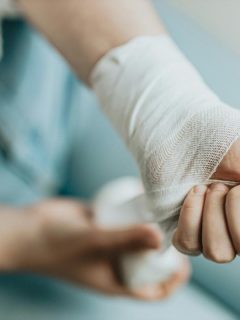 person wrapping their wrist with a bandage or gauze