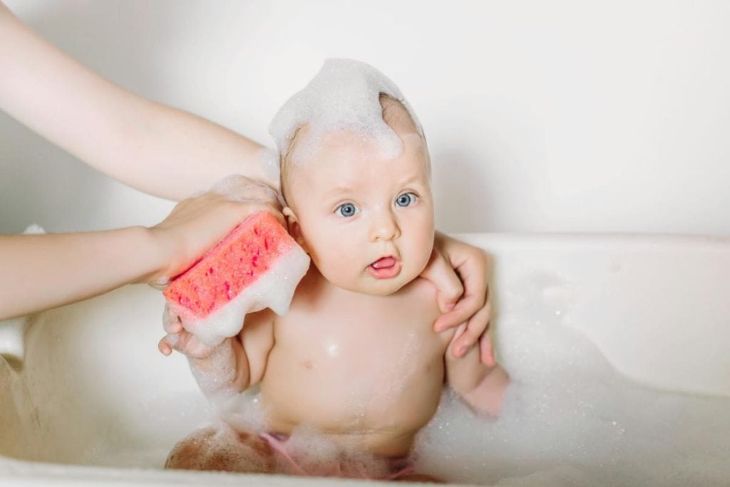 baby getting a bath in a tub