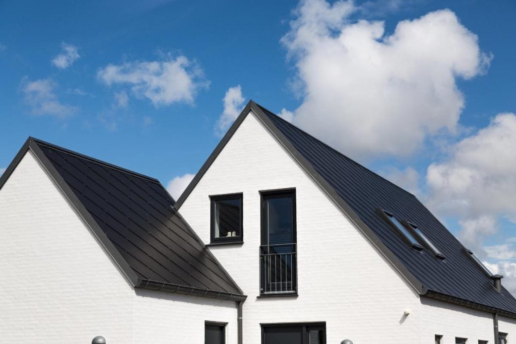 white house with black roof with steep pitch