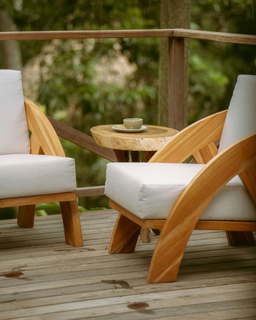 two chairs with white cushions on a wooden deck