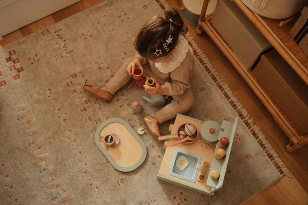 little girl playing with kitchen toys