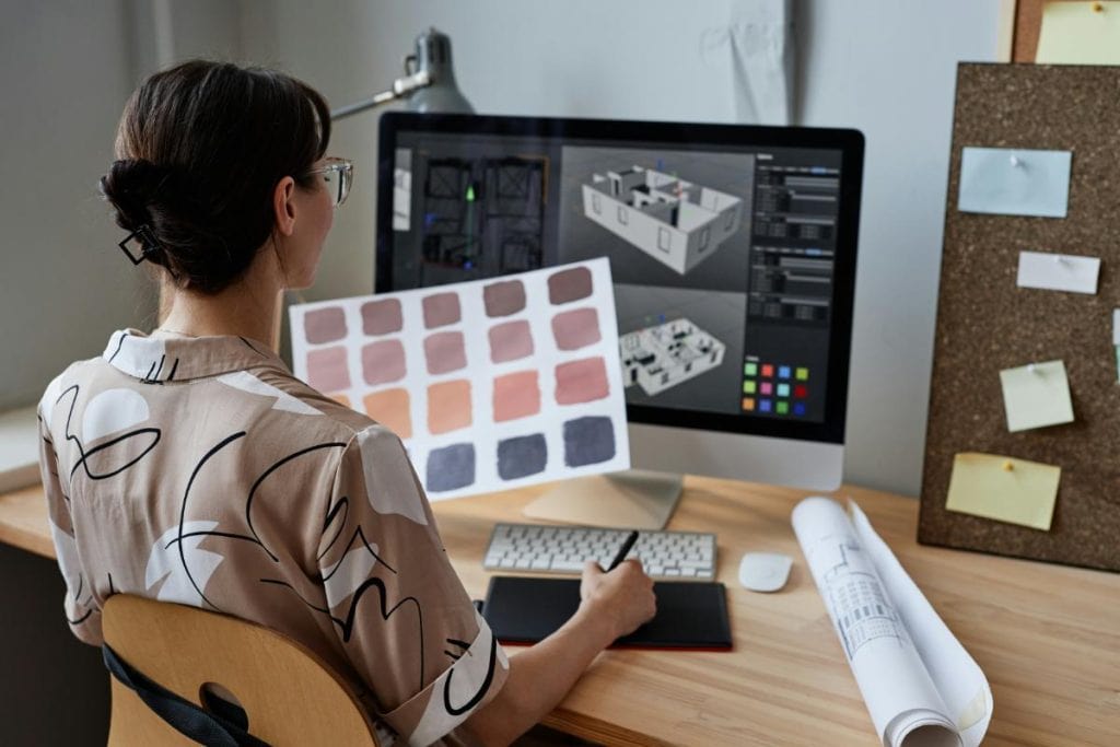 interior designer looking at color swatches and computer monitor